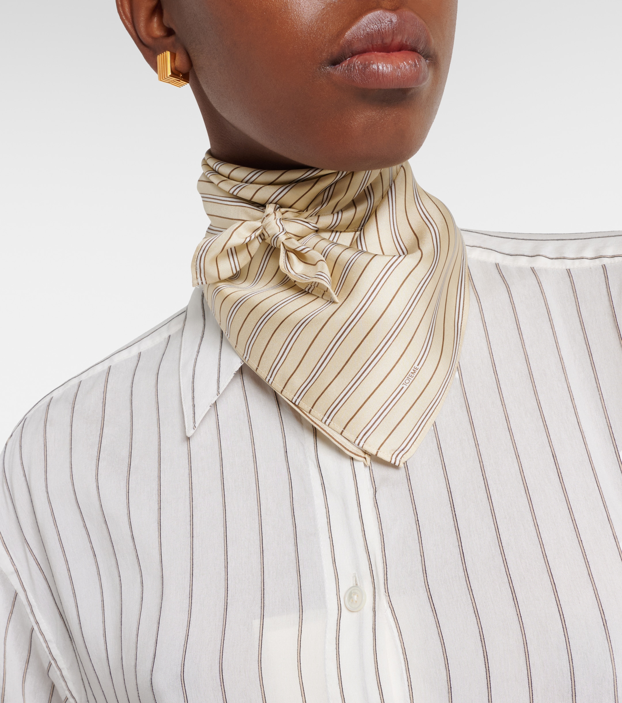 Striped silk scarf styled to add contrast to a monochrome outfit