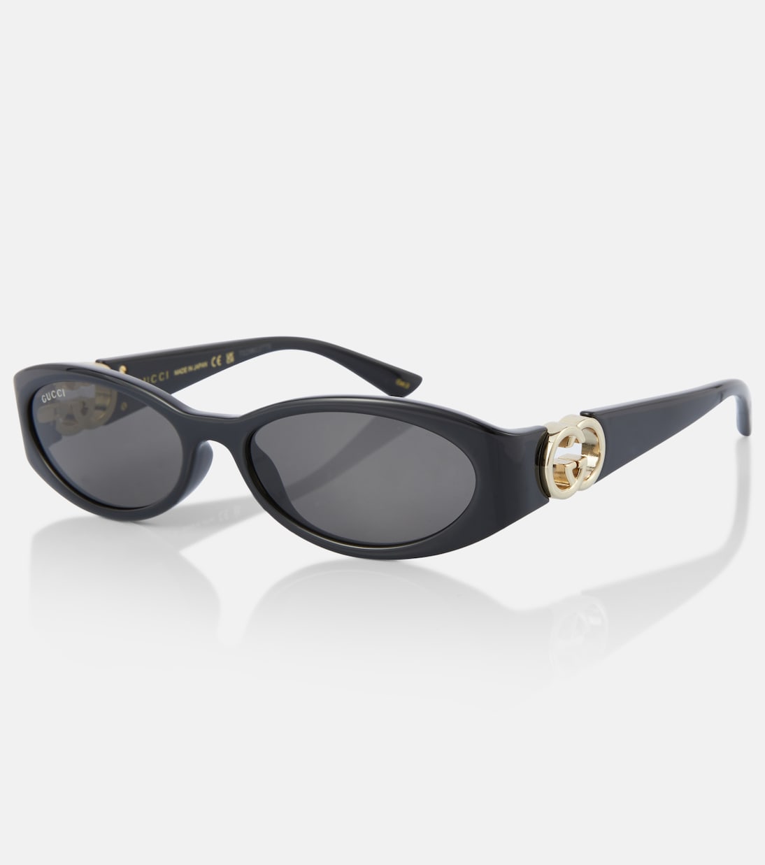Occhiali da sole GUCCI con design ovale e logo intrecciato, stile giovane e moderno.