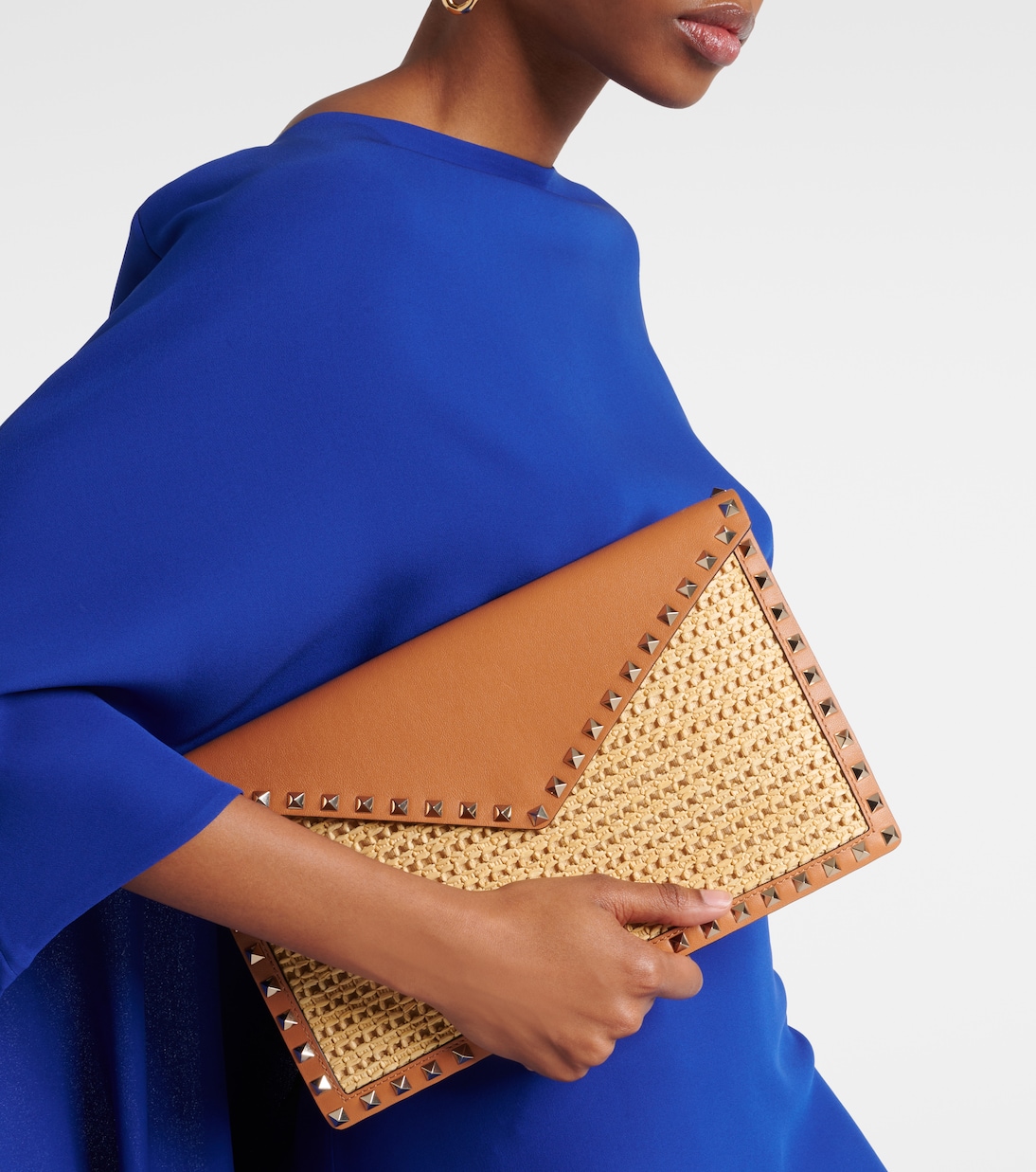 Rockstud Large leather-trimmed raffia clutch | Valentino Garavani