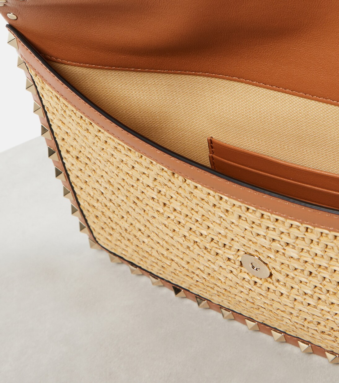 Rockstud Large leather-trimmed raffia clutch | Valentino Garavani