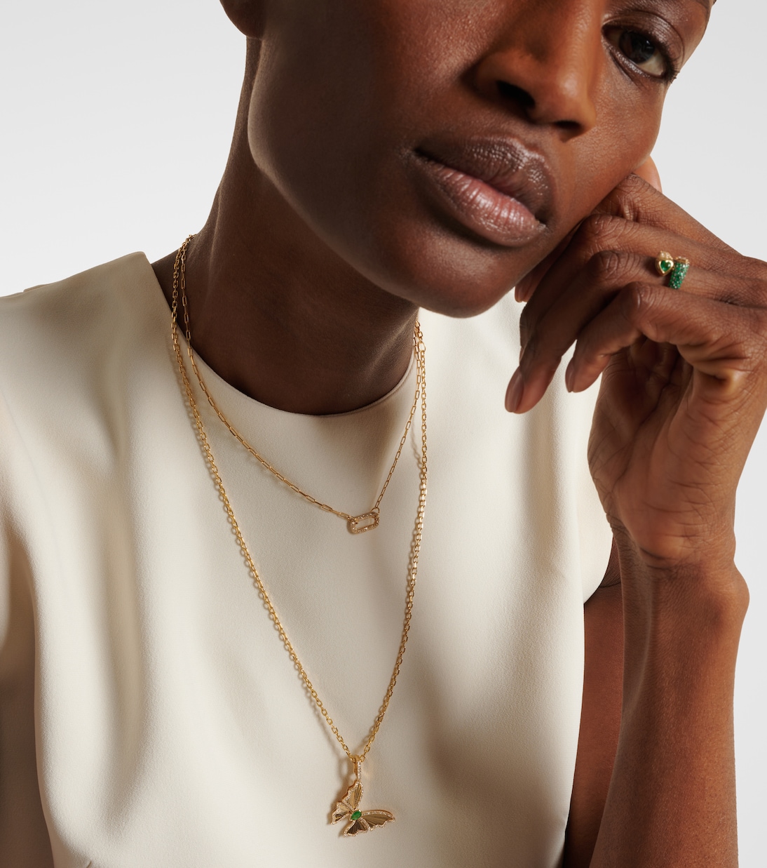 Collana giovanile con pendente farfalla in oro 18kt, decorata con smeraldi e diamanti, design elegante e moderno.