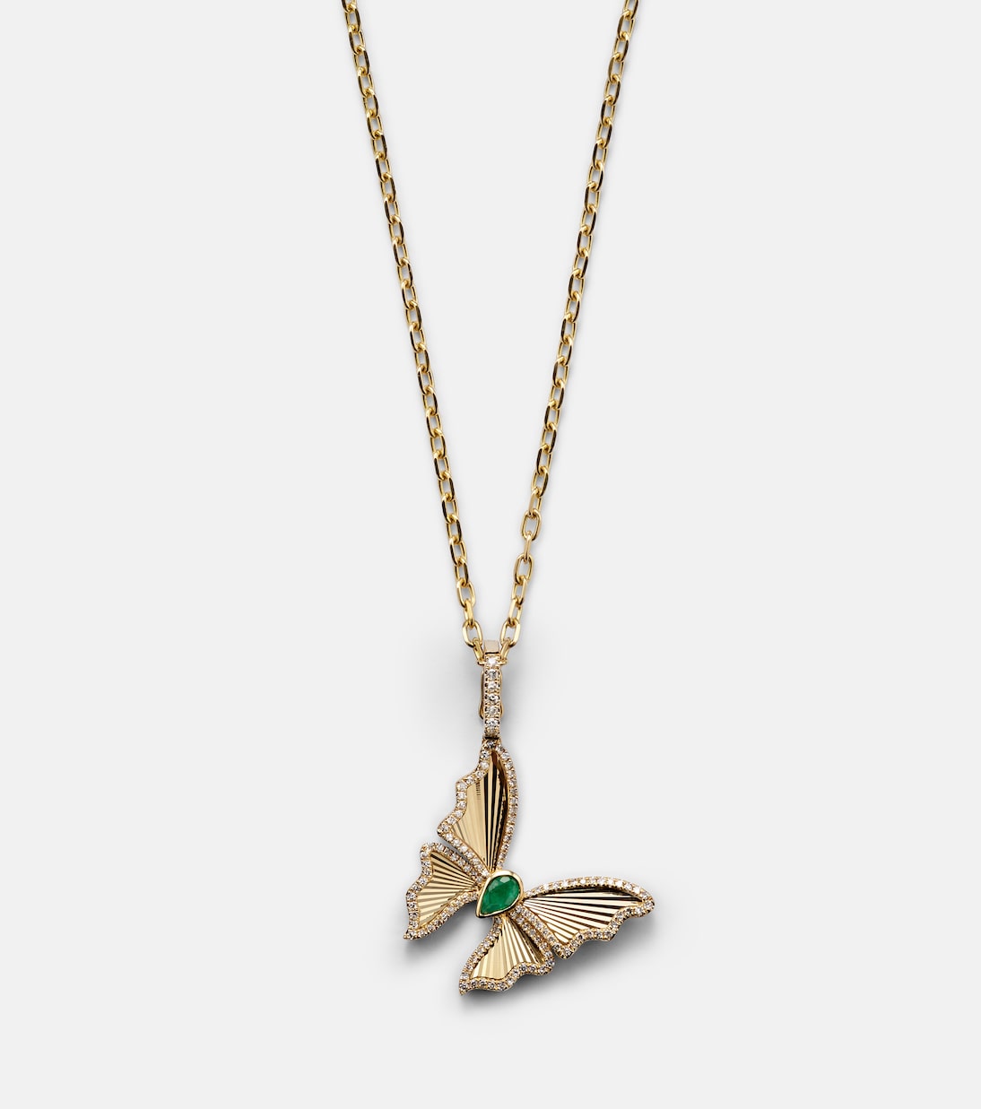 Collana giovanile con pendente farfalla in oro 18kt, decorata con smeraldi e diamanti, design elegante e moderno.