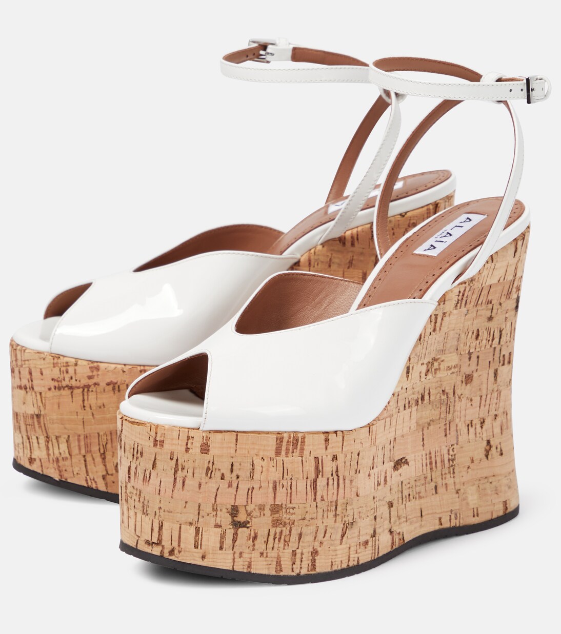 Patent leather wedge sandals in white Alaia Mytheresa