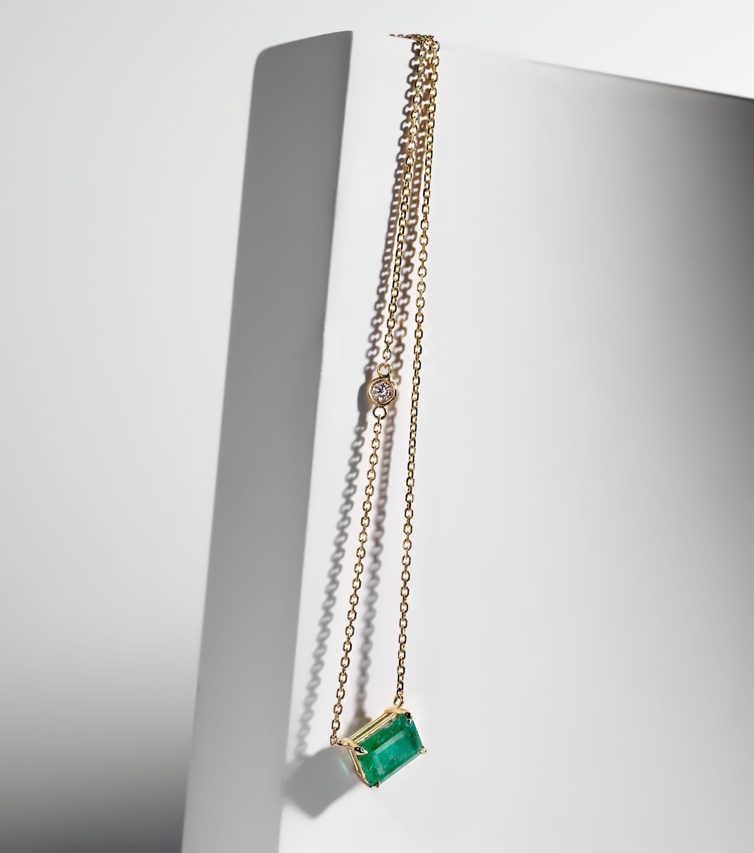 Collana moderna in oro giallo 18kt con smeraldo e diamanti, perfetta per giovani alla moda.